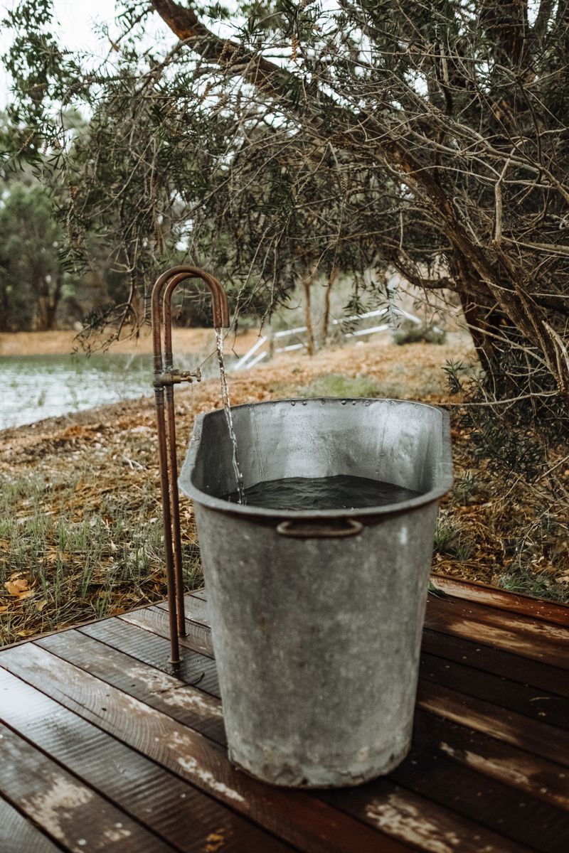 Galvanized metal stock tank tub in a winter outdoor setting — classic DIY cold plunge approach