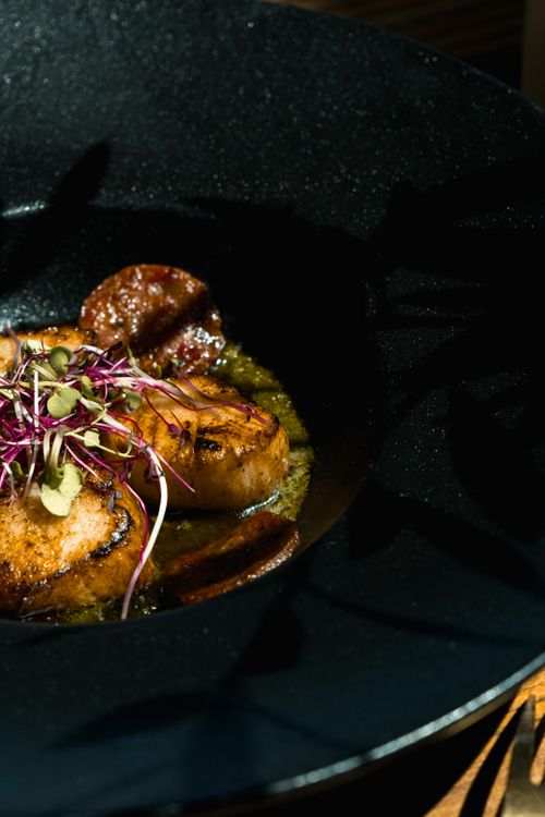 Free Close-up of seared scallops with microgreens in a stylish dark bowl, perfect for gourmet food lovers. Stock Photo