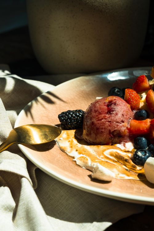 Free Artistic close-up of a dessert featuring mixed berries and ice cream, highlighting texture and vibrant colors. Stock Photo