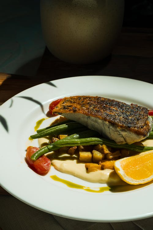 Close-Up Photo of a Cooked Fish on Top of Green Beans