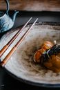 Close-up of a gourmet seafood dish with chopsticks, highlighting elegant presentation and fine cuisine.