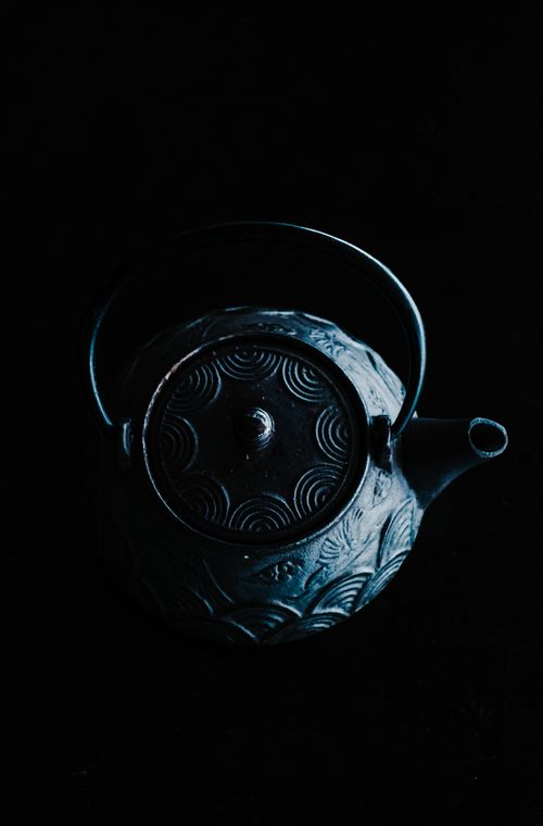 Free An artistic overhead shot of a decorative teapot against a black background. Stock Photo