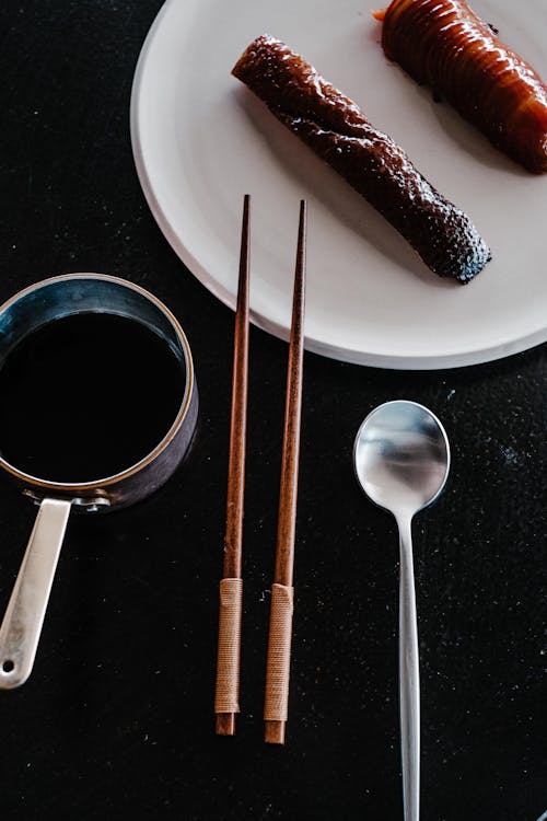 Spoon and Chopsticks near Plate with Food