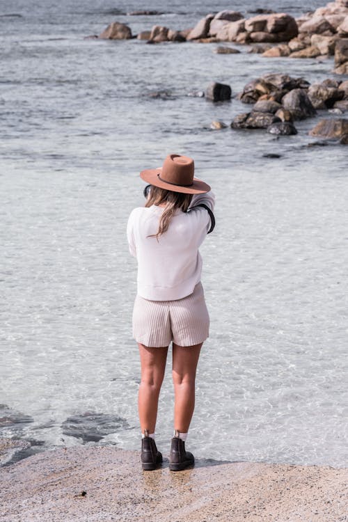 Woman Taking Pictures on Shore