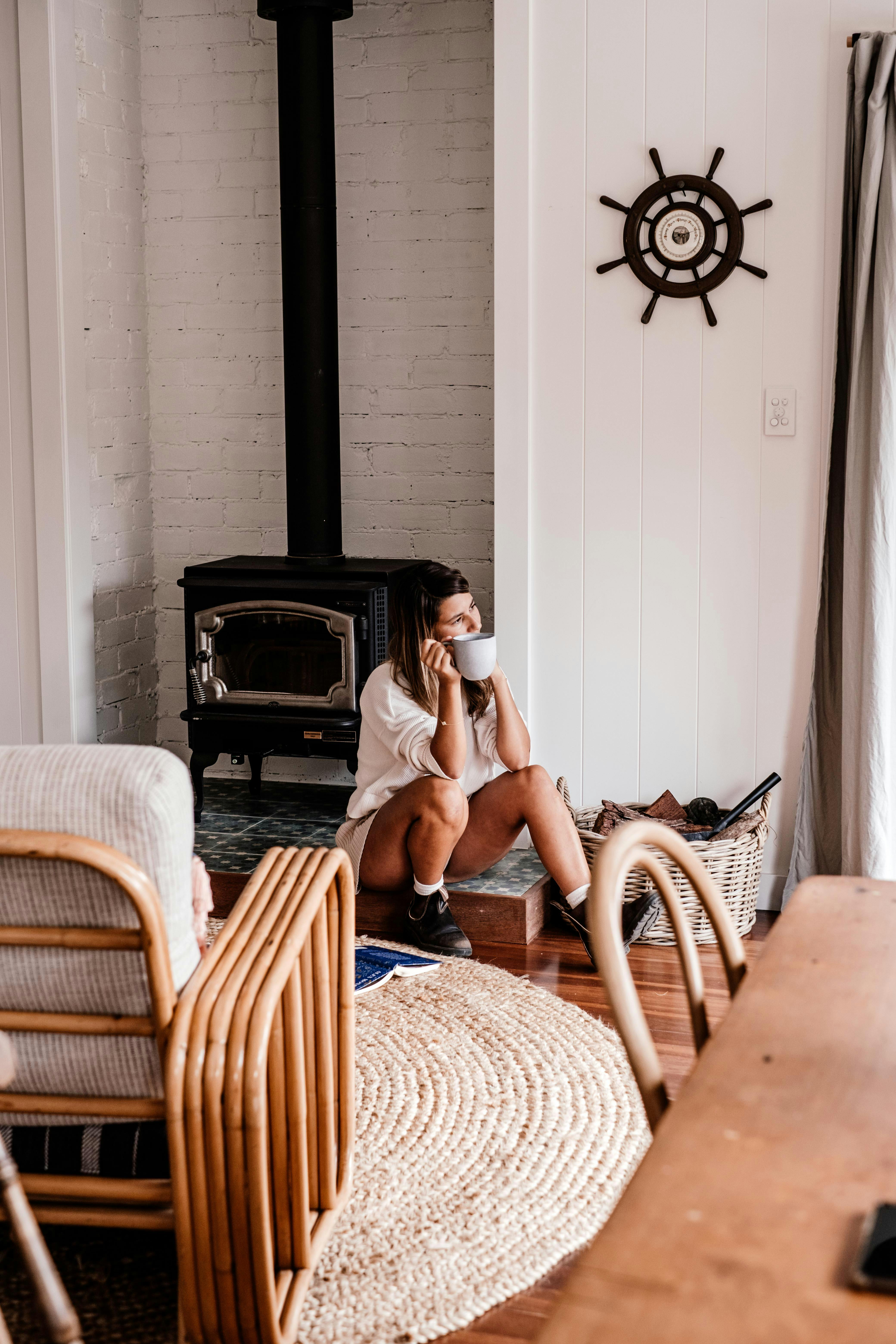 Free A serene living room environment with rustic elements, featuring a woman in a relaxed pose. Stock Photo