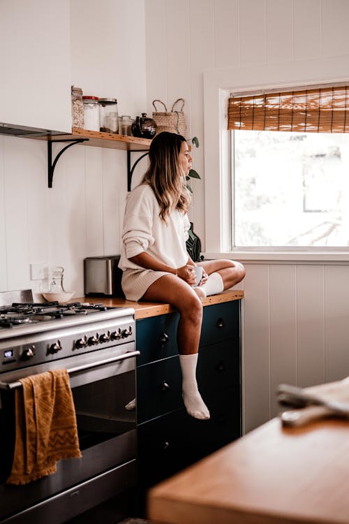 Woman Sitting on Furniture in Kitchen