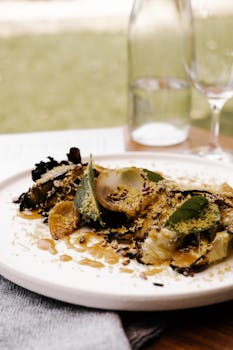 Gourmet salad with leafy greens and sesame dressing in an elegant restaurant setting.