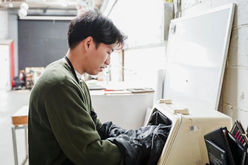Man Putting His Hands in a Machine in an Industry 
