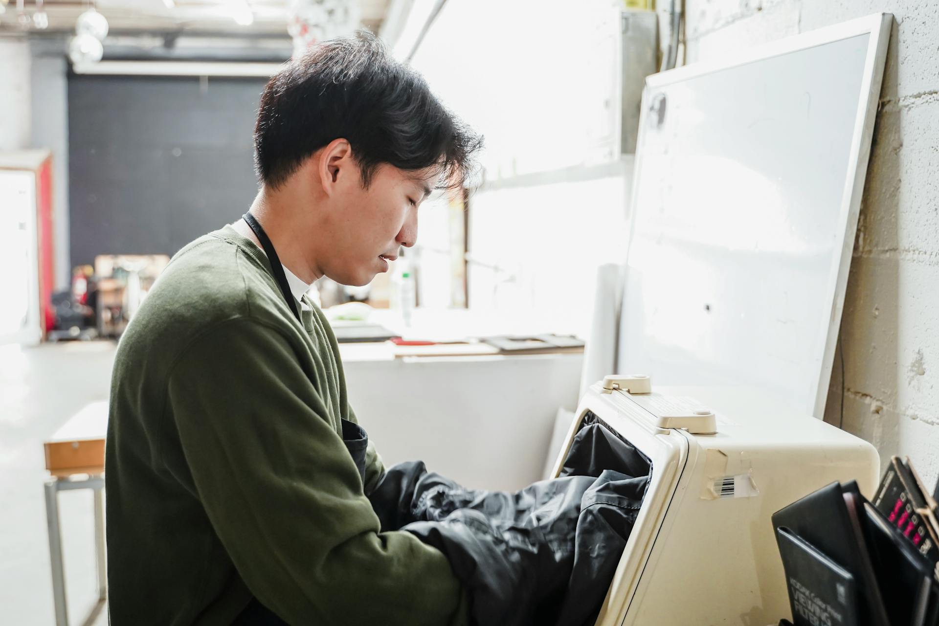 Man Putting His Hands in a Machine in an Industry