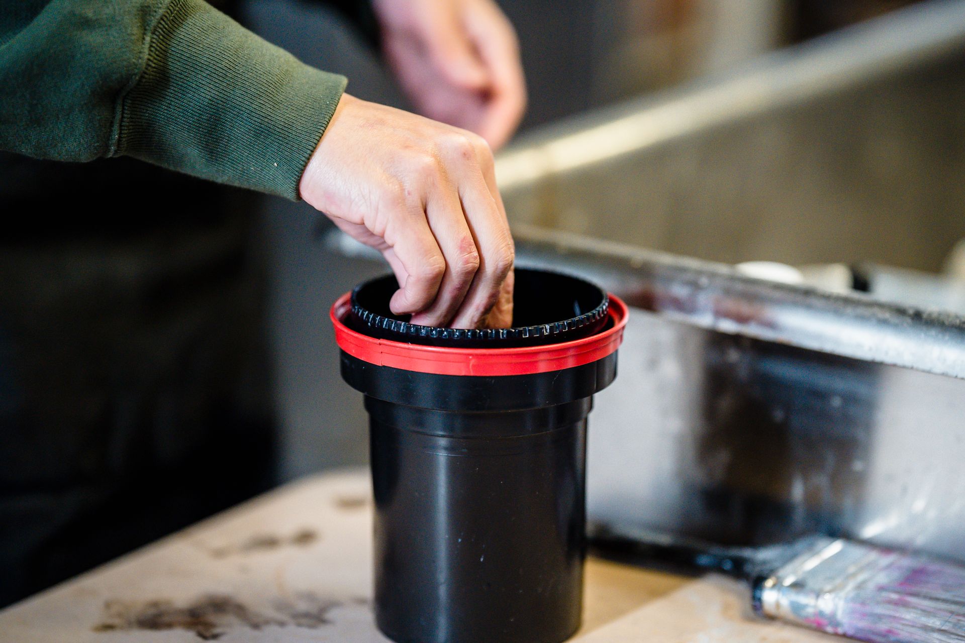 Hand Putting in Black Container