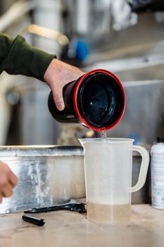 A close-up of pouring liquid into a measuring cup during film processing.