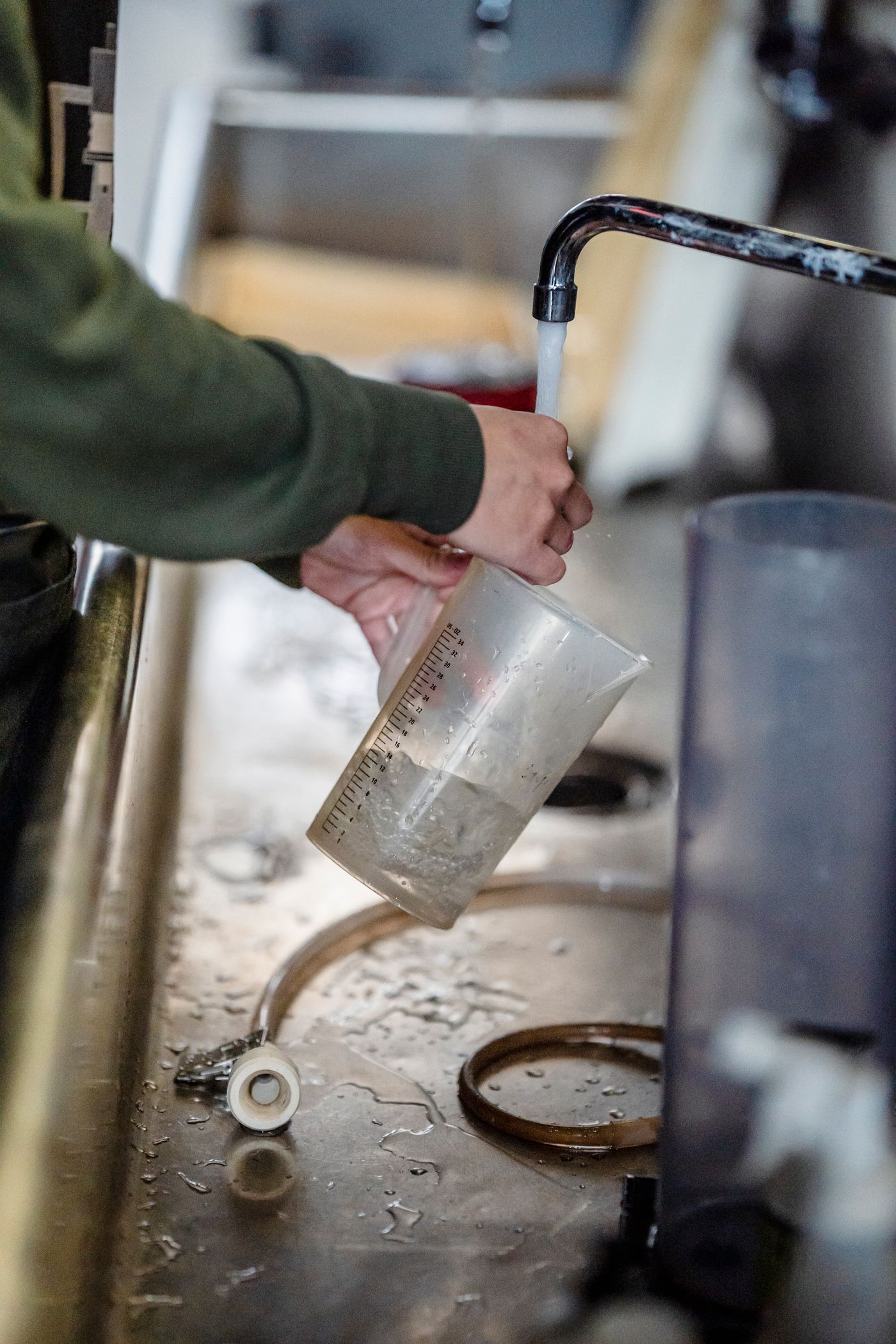 Measuring cup being filled with water for a controlled capacity check