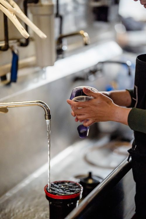 Free Close-up of hands holding film reel under running faucet in a darkroom. Stock Photo