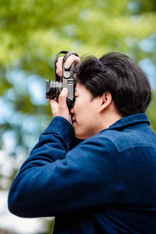 Man in Denim Jacket Taking Photo