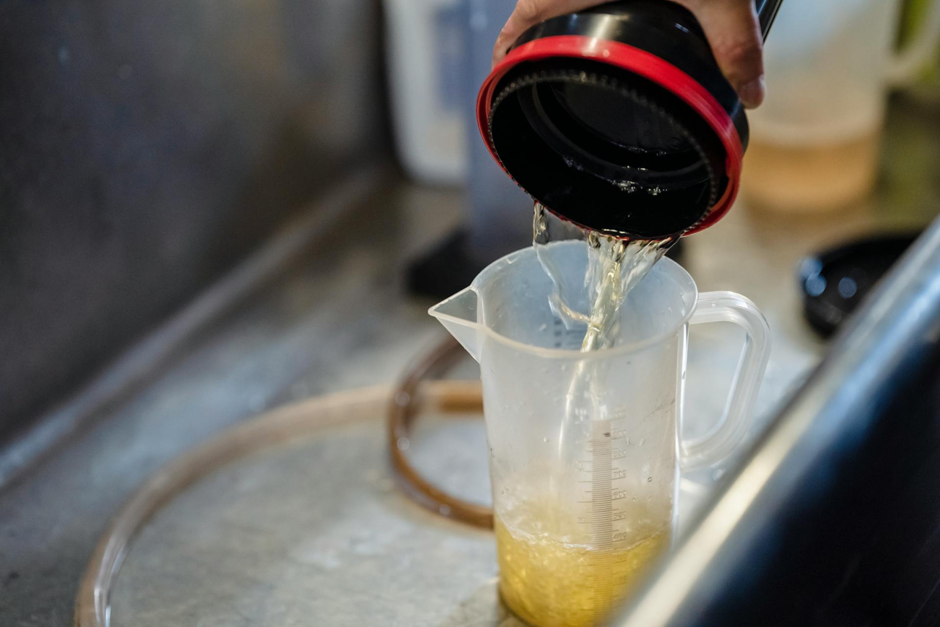 Detailed view of water being poured into a measuring cup, perfect for illustrating precision in liquid measurement.