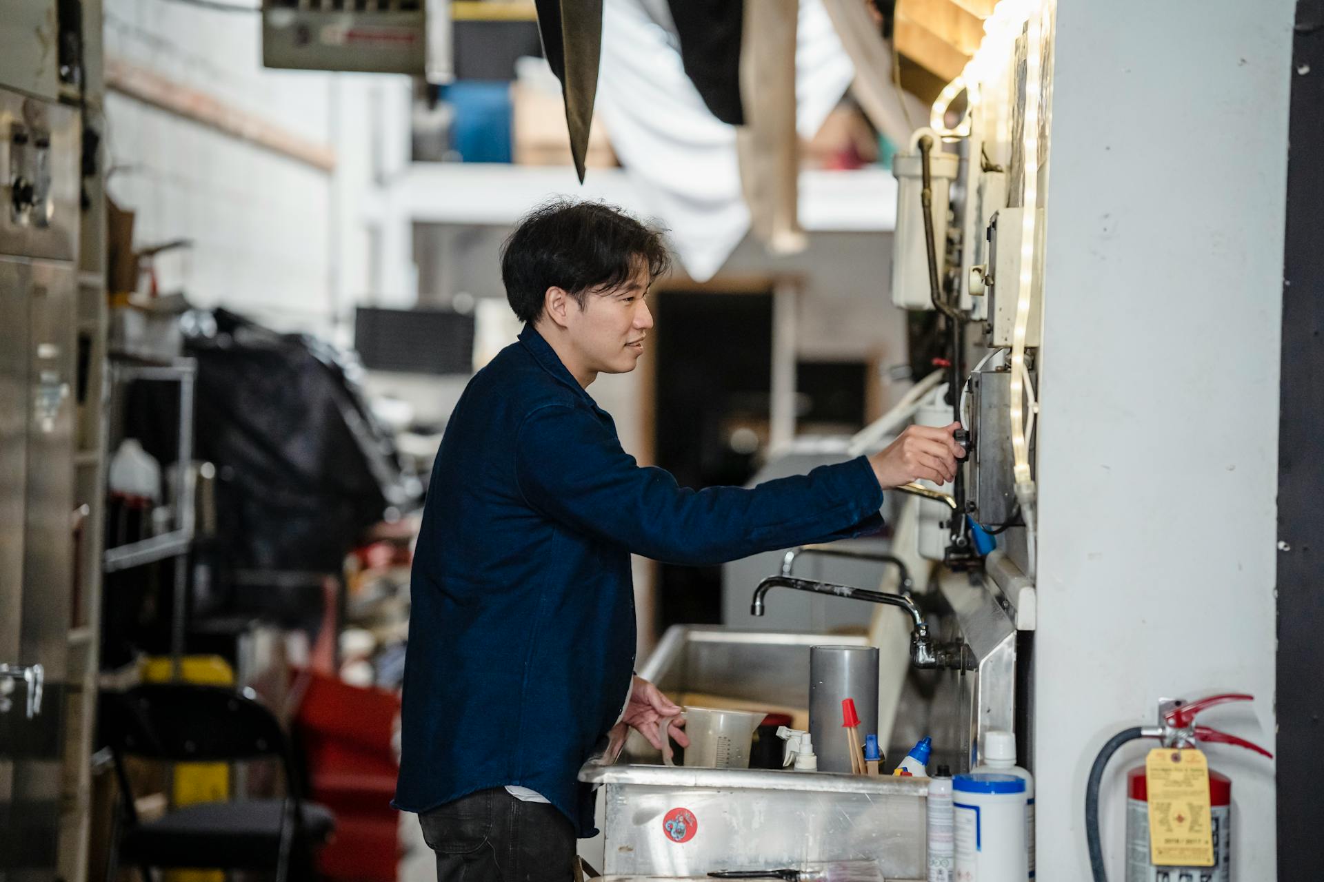 A man smiling while operating machinery in an industrial workspace.