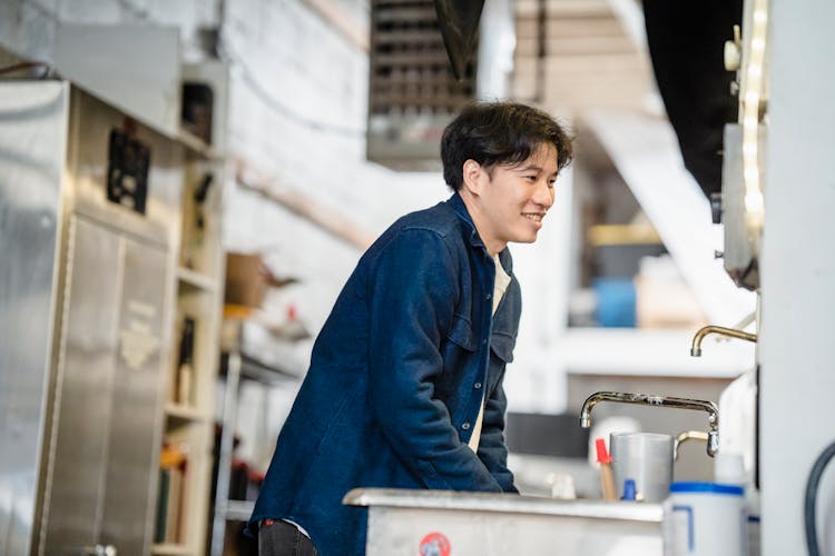 Man Washing His Hands In A Sink In A Factory 