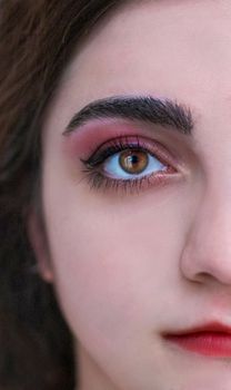 Artistic close-up showcasing eye makeup and lipstick on a woman's face for beauty concepts.