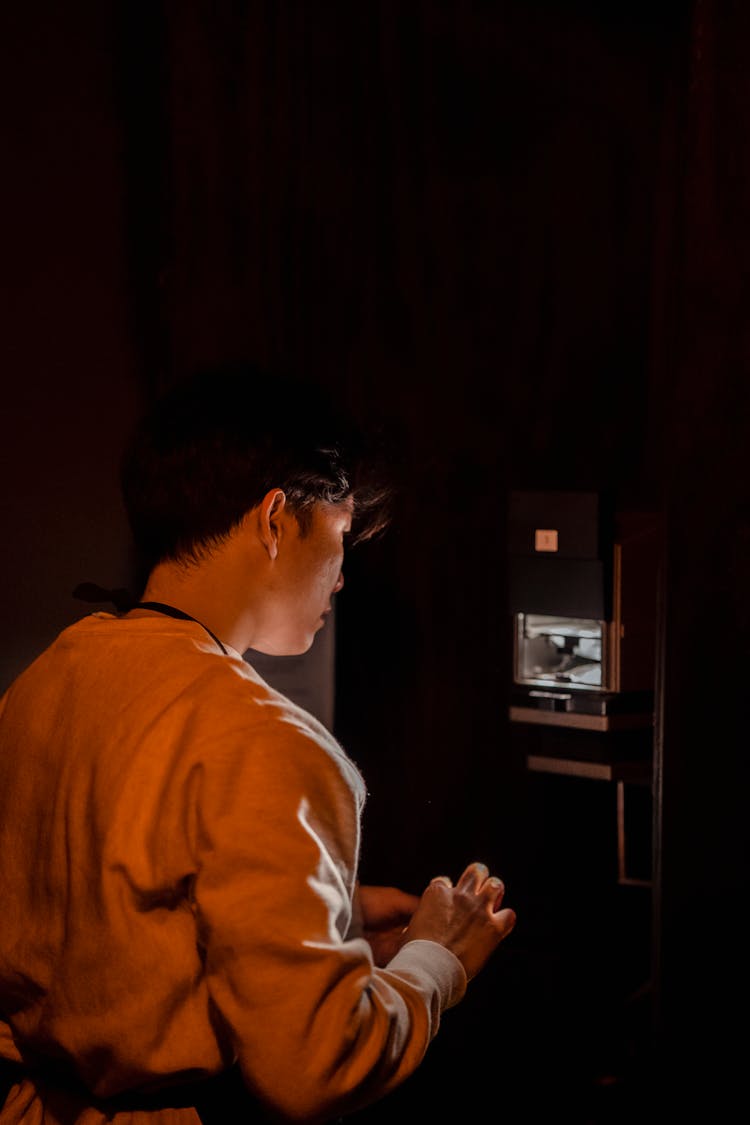 Man Using Developing Equipment In Darkroom