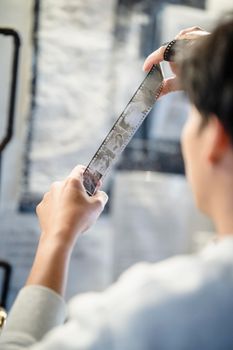 Close-up of a person examining a film negative, showcasing photography development process.