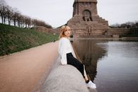 A Woman in White Knitted Sweater Sitting Beside the Lake