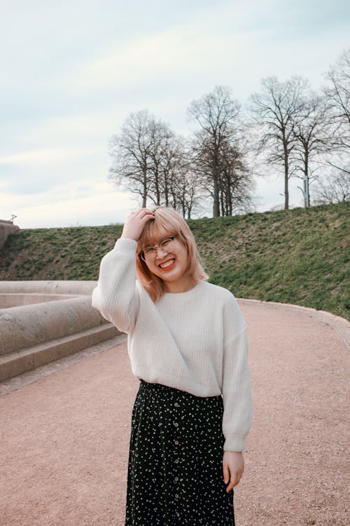 A Woman Smiling while Wearing White Knitted Sweater