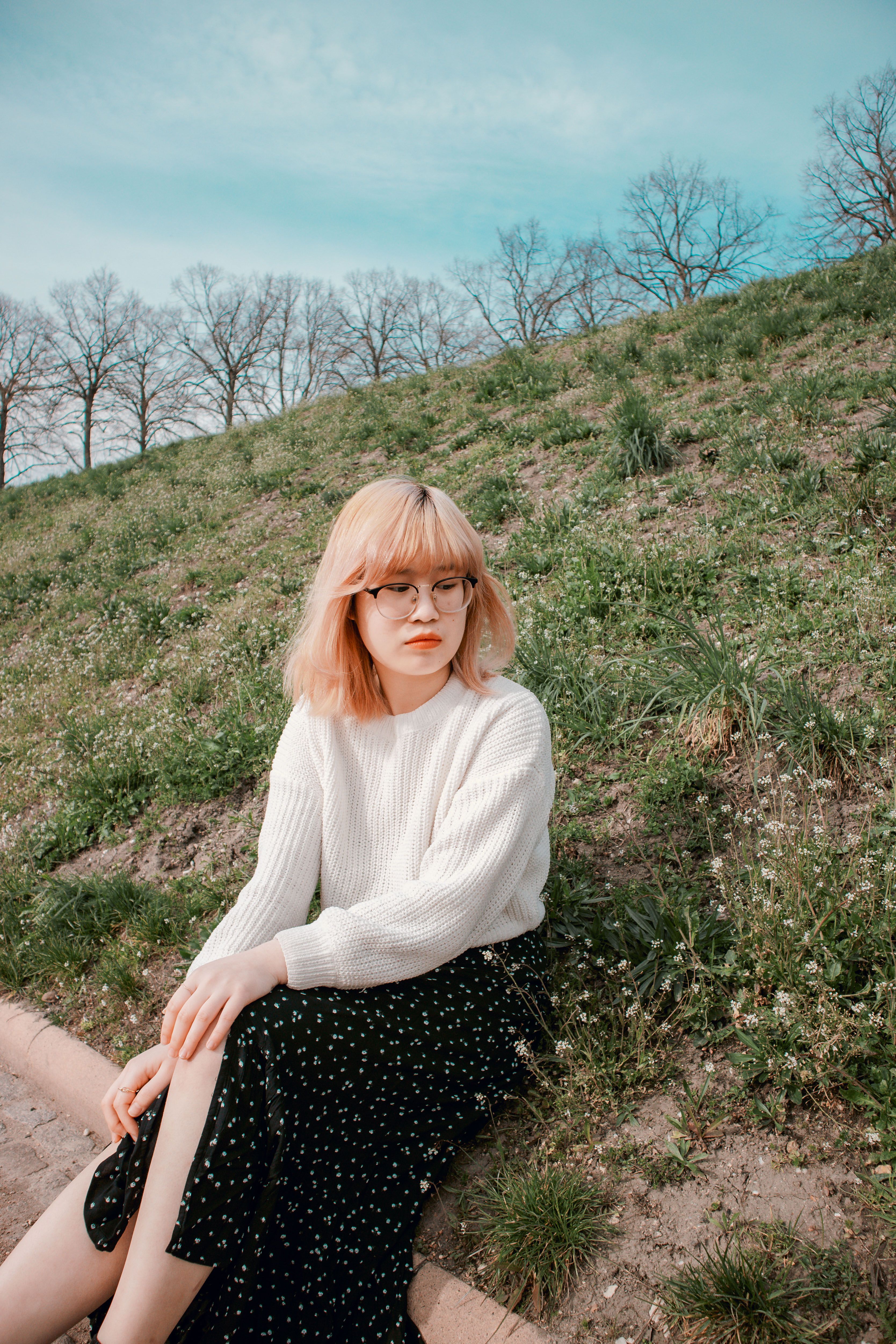A Woman in White Sweater Sitting on the Grass · Free Stock Photo