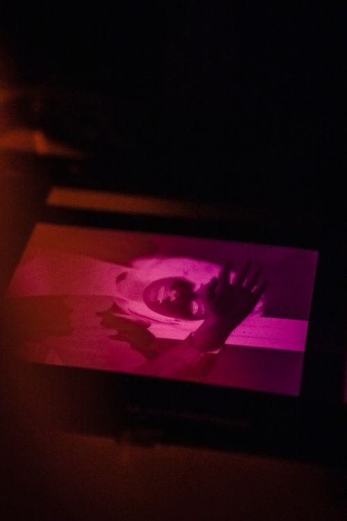 Free Captivating darkroom environment showing a photograph being developed under red light, highlighting the art of traditional photography. Stock Photo