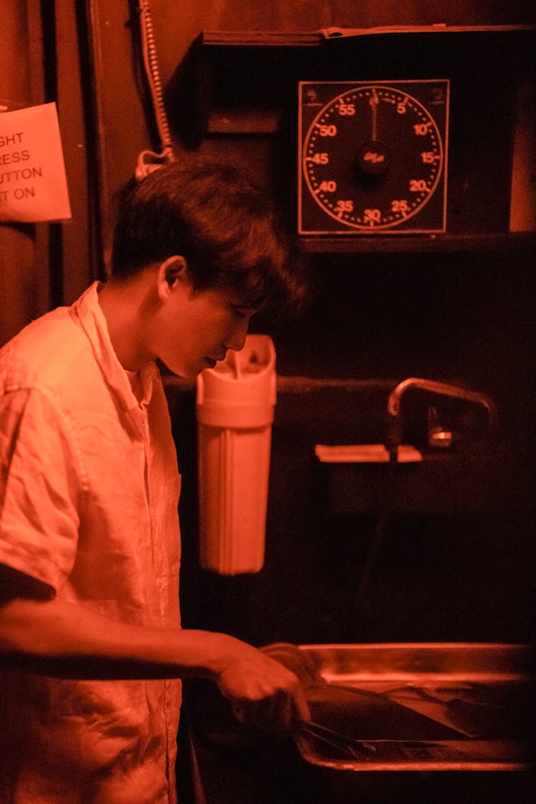 Man Developing Photographs In Darkroom