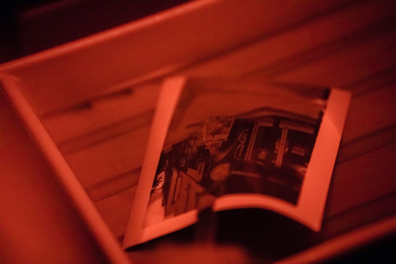 a traditional analog photograph being developed in a darkroom under re