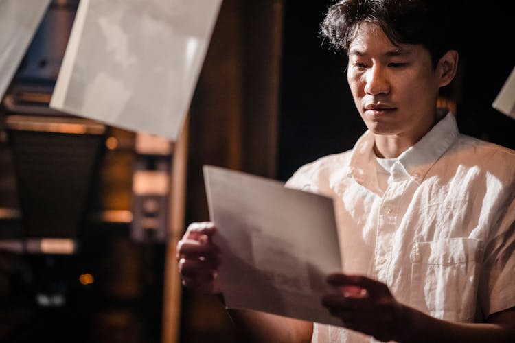 Portrait Of Photographer Working In Dark Room With Photos