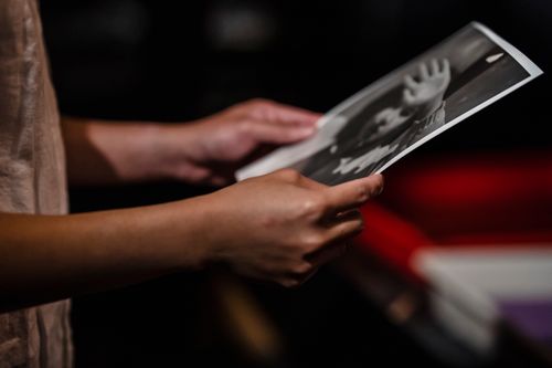 Free A close-up view of hands holding a black and white photo, emphasizing the texture and depth. Stock Photo