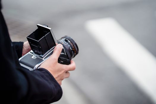 A close-up shot of hands holding a classic Hasselblad camera outdoors, perfect for photography enthusiasts.