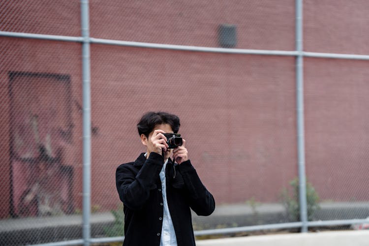 Man Taking Picture With Camera Outdoors