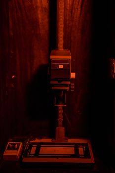 Classic darkroom scene featuring an enlarger under red lighting, ideal for film photography.