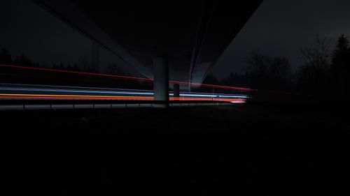 Free Captivating long exposure shot capturing vibrant light trails beneath a bridge at night. Stock Photo