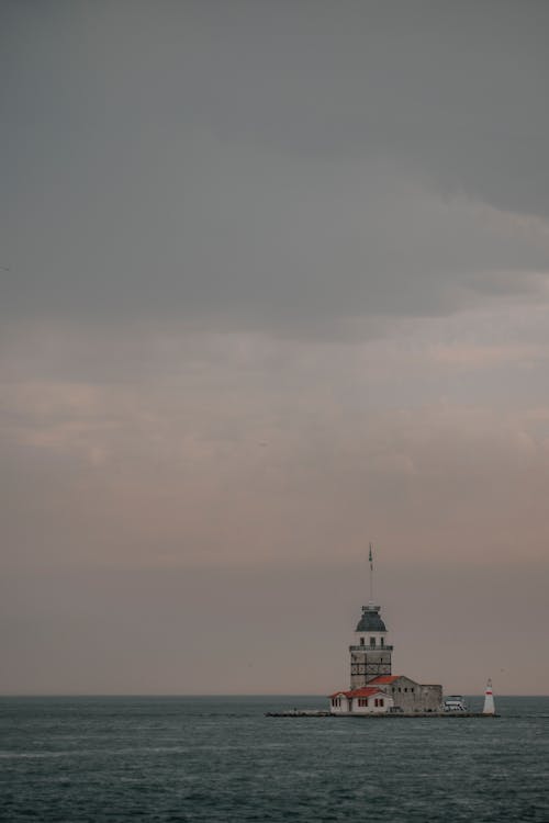 White Lighthouse Building Under Grey Sky