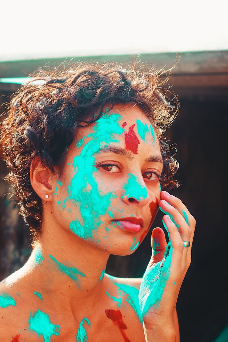 A Woman With Blue And Red Powder On Face