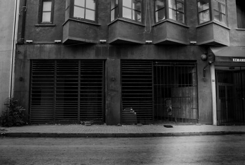 Free Detailed black and white photo of a building facade in İstanbul with glass windows and metal gates. Stock Photo