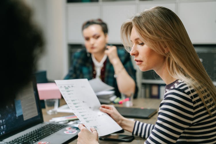 Woman Holding A Paper While In A Meeting