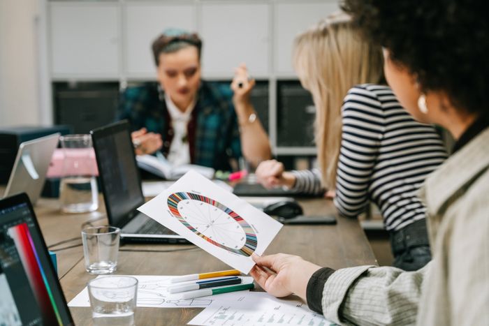 Colleagues planning around a colour wheel in a studio — photo by Ivan S on Pexels