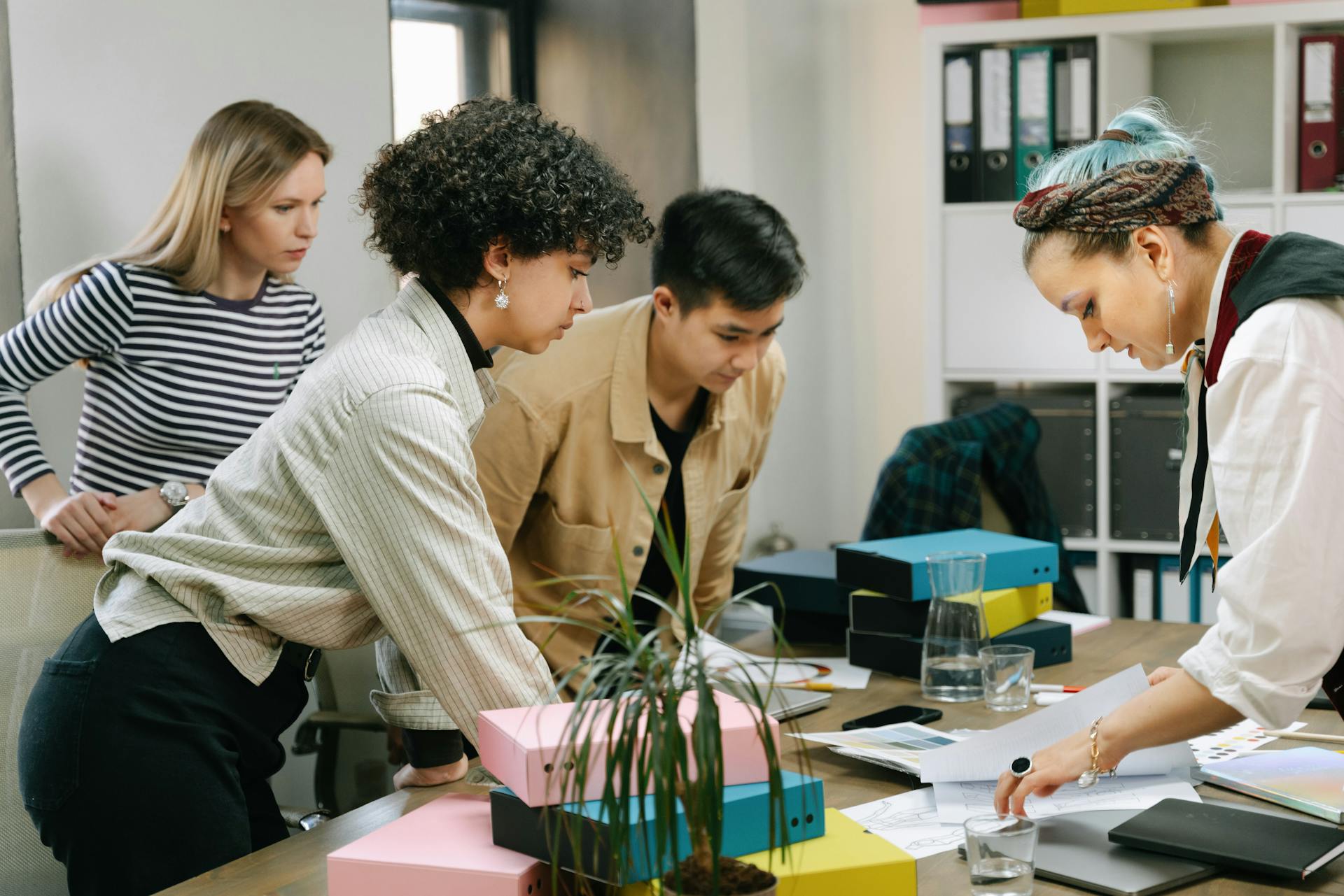 A diverse team of colleagues collaborating on a business project in a modern office setting.