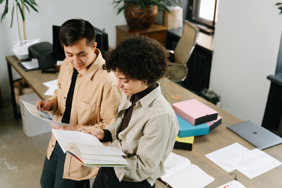 Two colleagues discuss planning strategies in a modern office setting