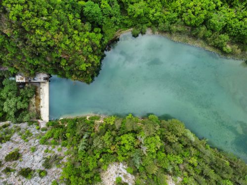 Free Aerial shot capturing a tranquil lake surrounded by lush green forest. Stock Photo