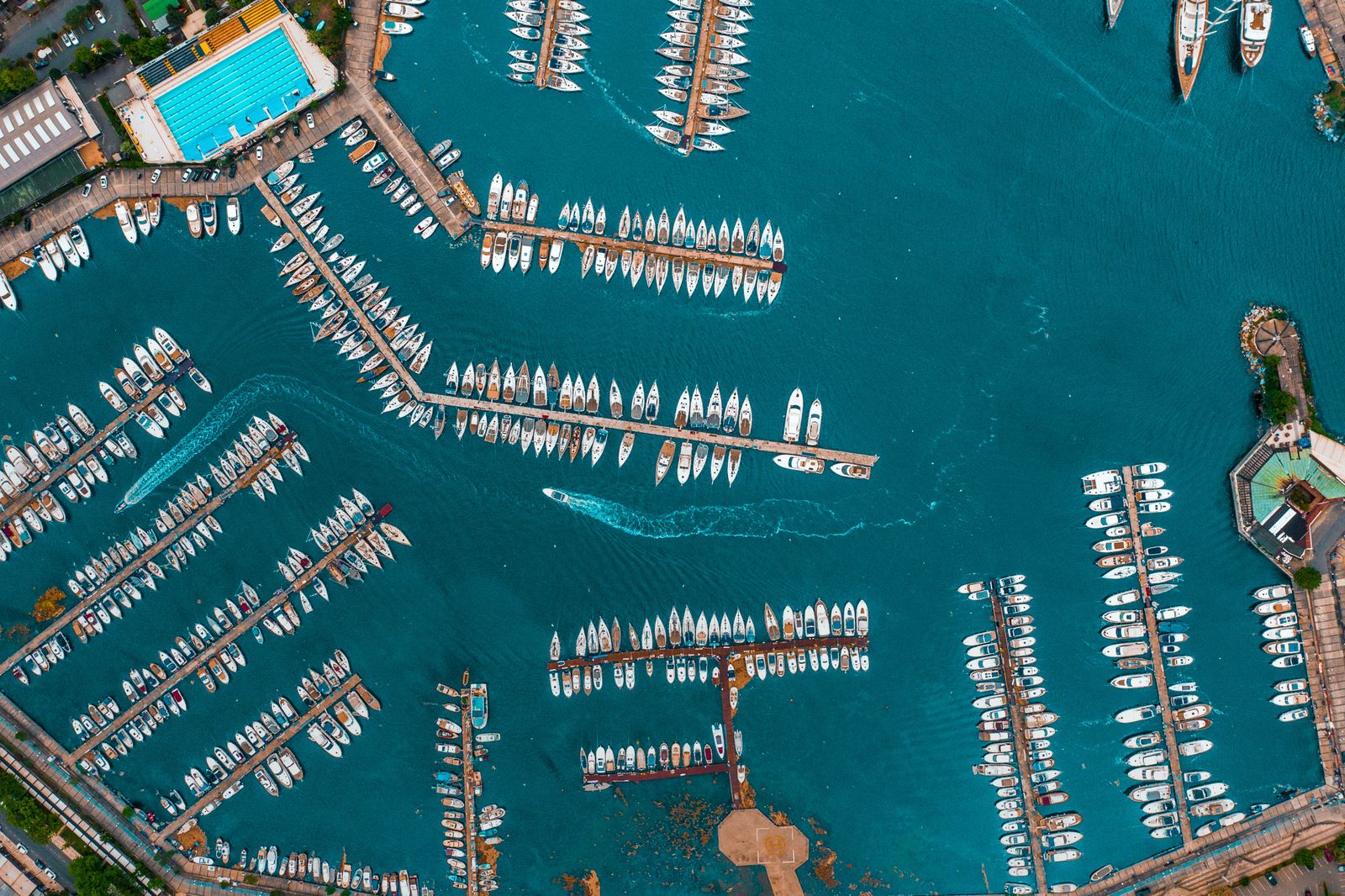 Aerial view of yachts docked in a marina on calm blue water