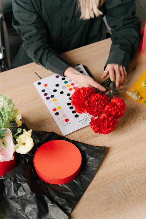 Free A Person Holding a Bouquet of Red Carnation Flowers Stock Photo