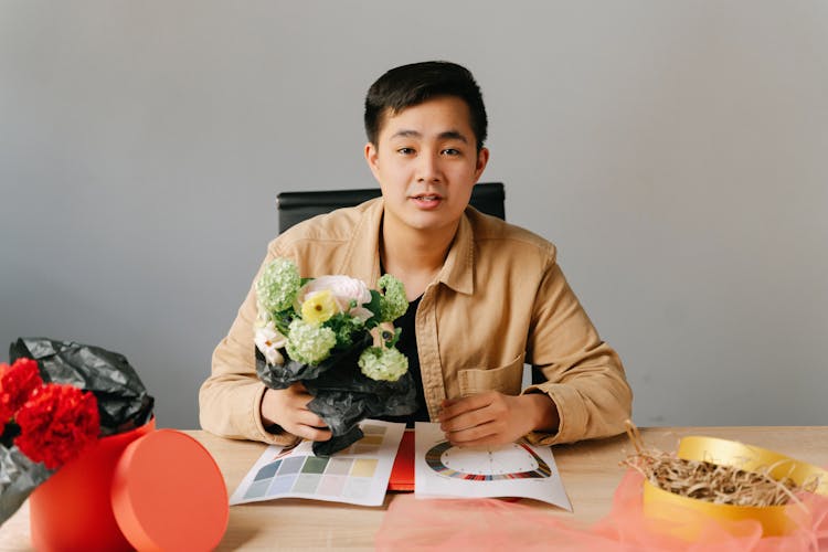 A Man Sitting Holding A Flowers