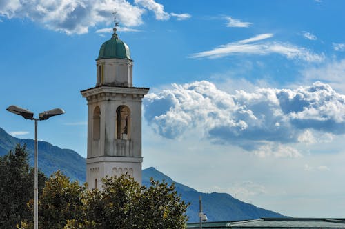 Green Dome Roof of a Church Under the Blue Sky and White Clouds