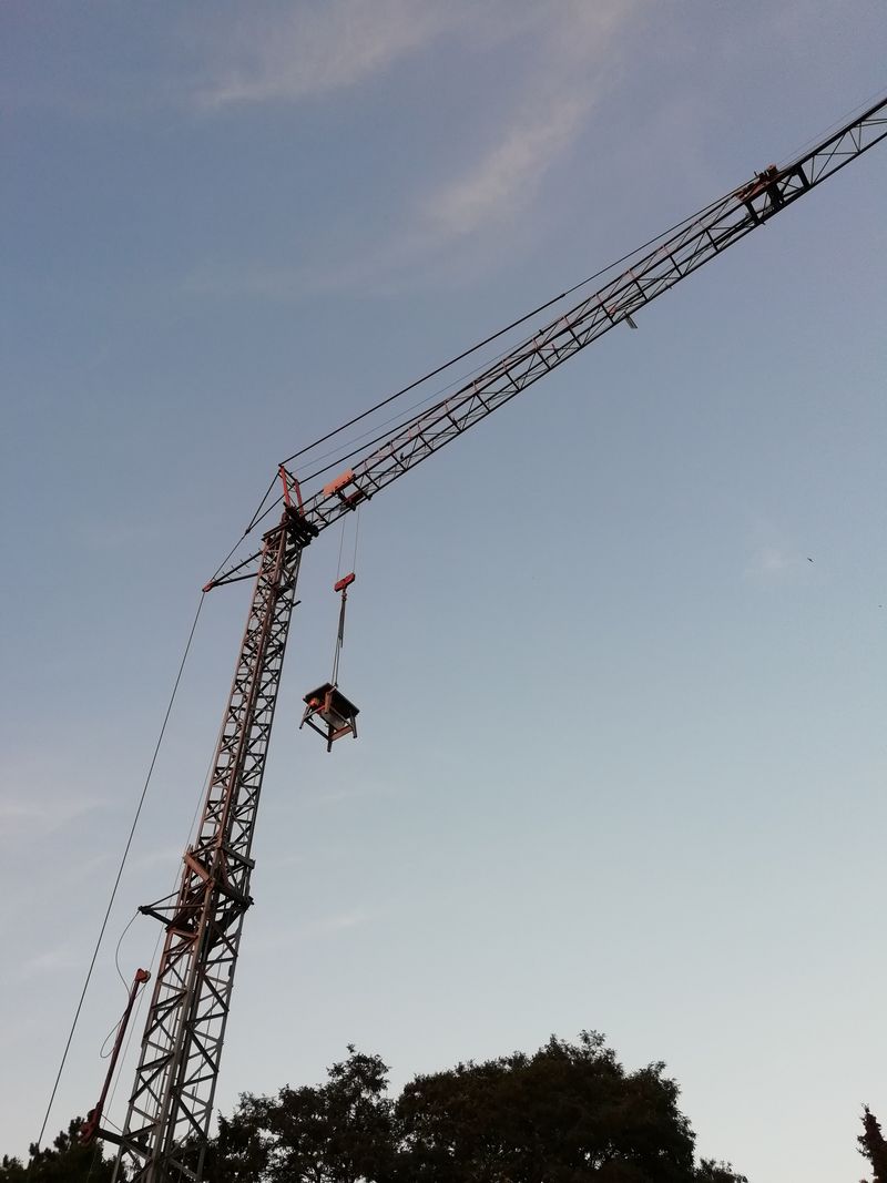 Tower crane lifting a load on a clear day