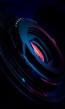 Close-up of a speaker cone illuminated with vibrant neon lighting. Abstract and modern feel.